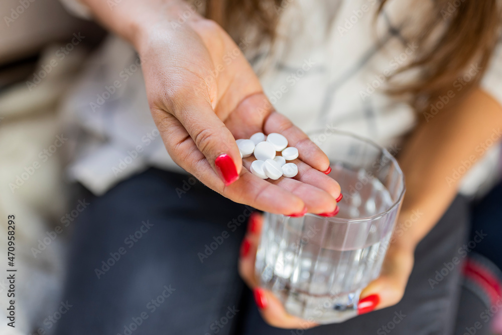 girl holding medicine pills in her hands for anesthesia and treatment with a glass of water girl holding medicine pills in her hands for anesthesia and treatment with a glass of water