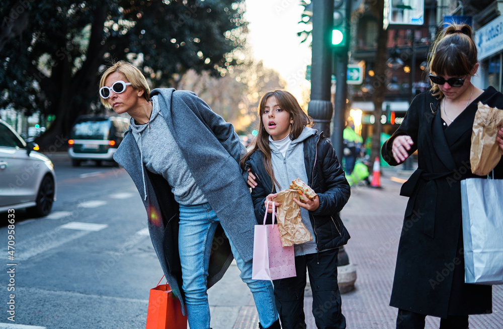 Happy women with purchases waiting for a taxi in the city Happy women with purchases waiting for a taxi in the city