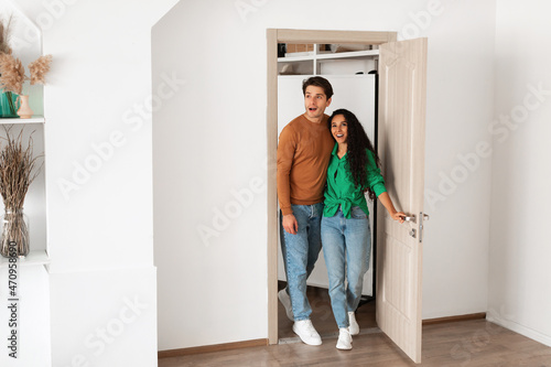 Portrait of excited emotional couple walking in their apartment