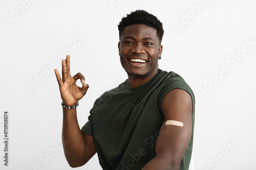 Smiling african american male patient got vaccinated, showing okay
