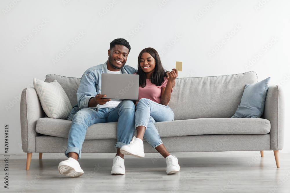 Black couple using pc and credit card at home Black couple using pc and credit card at home