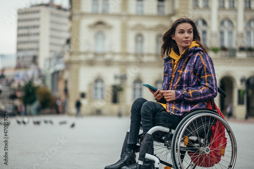 Woman with disability using a smartphone while out in the city © Zamrznuti tonovi