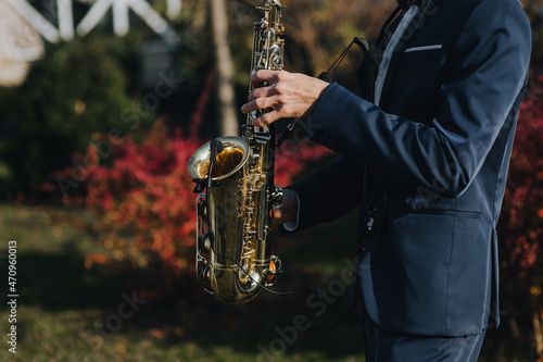 A man in a suit, saxophonist, musician plays the saxophone with a microphone. Close-up portrait. photo