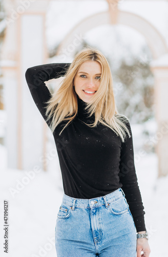 Close-up winter portrait of young woman with blond hair in the park