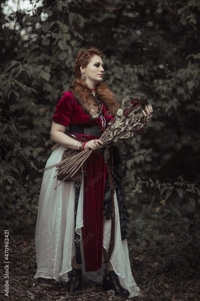 Witch with short hair in dress against the background of wild nature Witch with short hair in dress against the background of wild nature