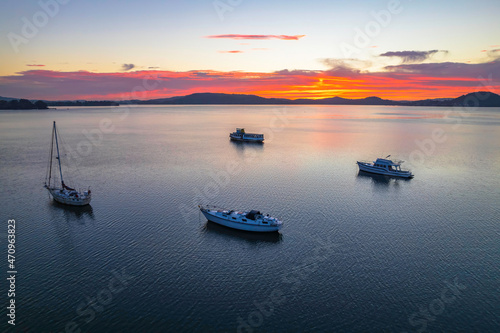 Pink and purple sunrise waterscape with boats