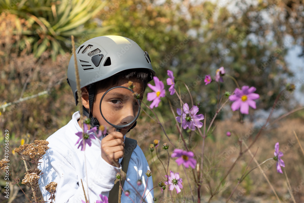 Boy using a helmet observing a plant Boy using a helmet observing a plant