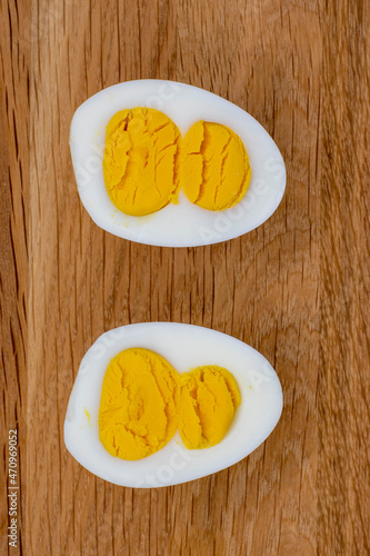 Sliced egg with two yolks on wooden background, 8 march holiday concept