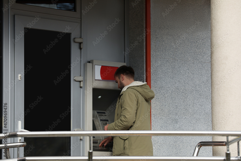 Man using cash machine for money withdrawal outdoors Man using cash machine for money withdrawal outdoors