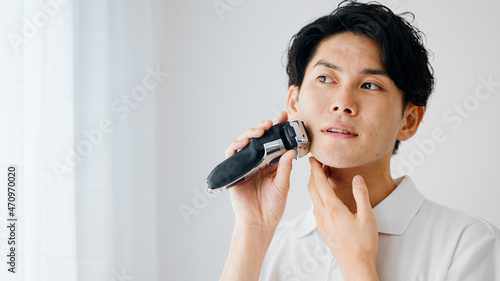 Foto 髭剃りをする若い男性