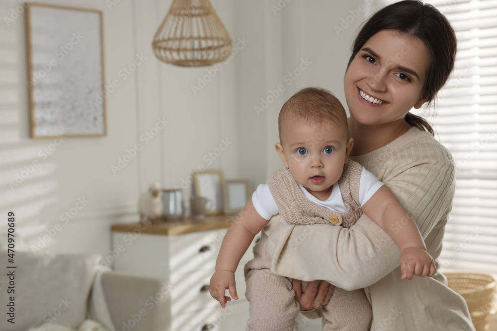 Happy young mother with her baby in living room. Space for text Happy young mother with her baby in living room. Space for text