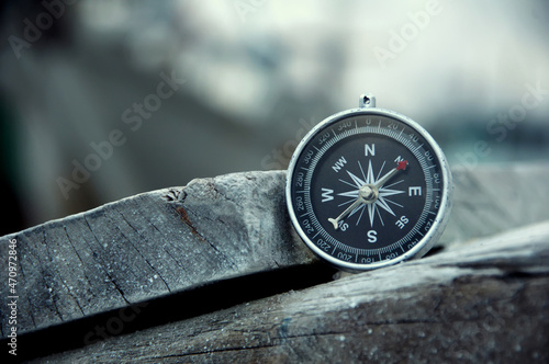 Close up of navigational compass on a pile of wood