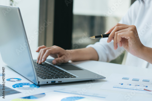 Business woman using calculator for do math finance on wooden desk in office and business working background, tax, accounting, statistics and analytic research concept
