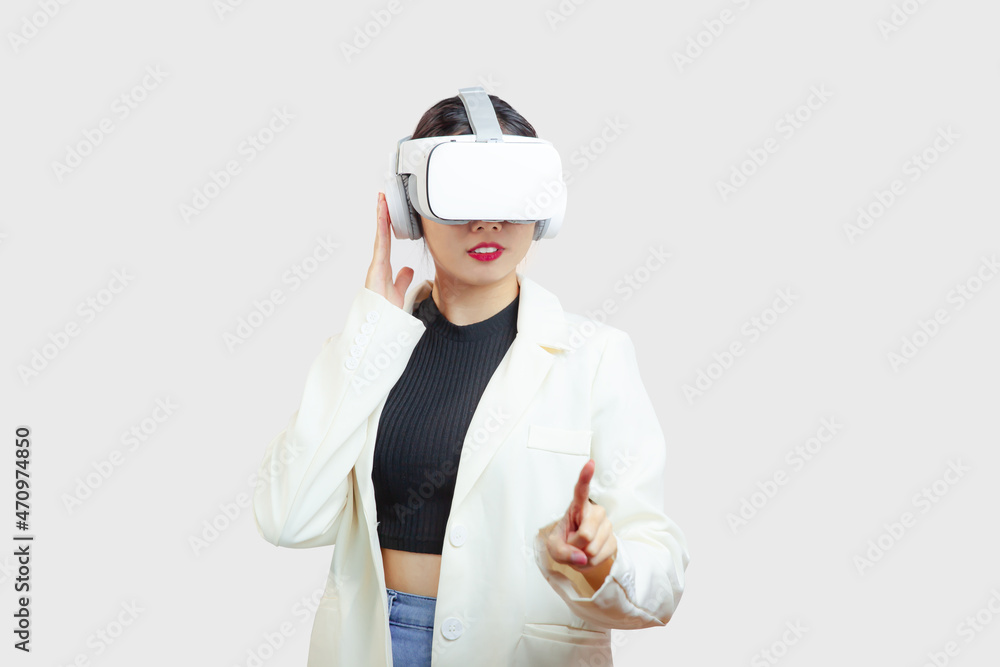 Metaverse, asian woman in white jacket wearing virtual reality glasses pointing and touching on the white background. Metaverse, asian woman in white jacket wearing virtual reality glasses pointing and touching on the white background.