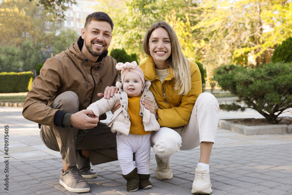 Fototapeta premium Happy parents with their baby in park on sunny day