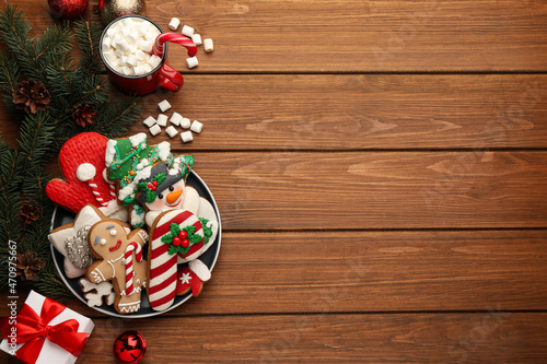 Delicious homemade Christmas cookies, cocoa and festive decor on wooden table, flat lay. Space for text