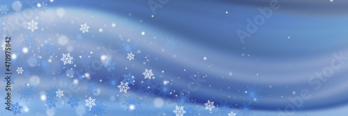 Beautiful white snowflakes and bokeh on a blue background. Panoramic Christmas background with copy-space.