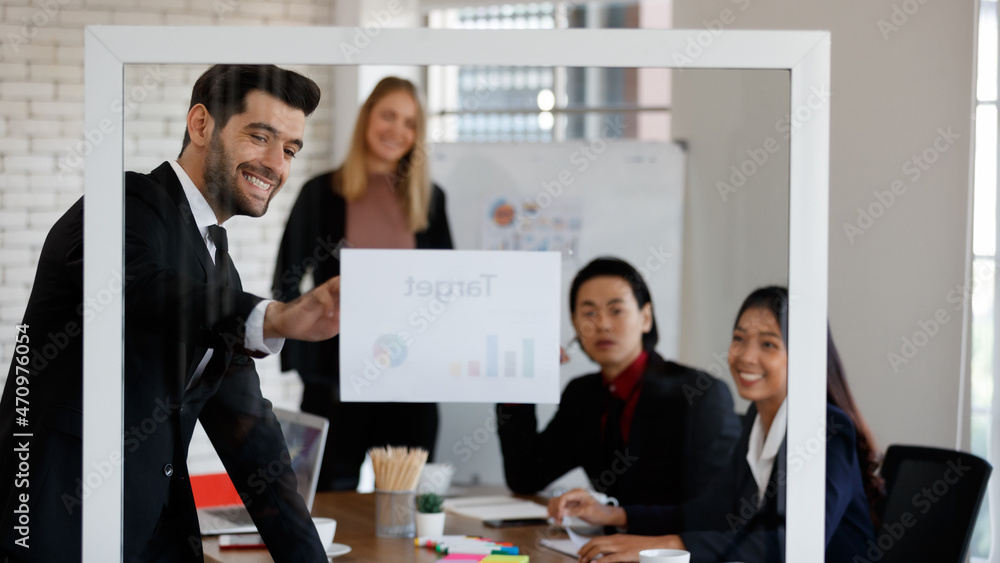 Through glass of multiethnic colleagues looking at diagrams Through glass of multiethnic colleagues looking at diagrams