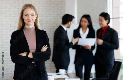 Optimistic businesswoman near multiracial colleagues