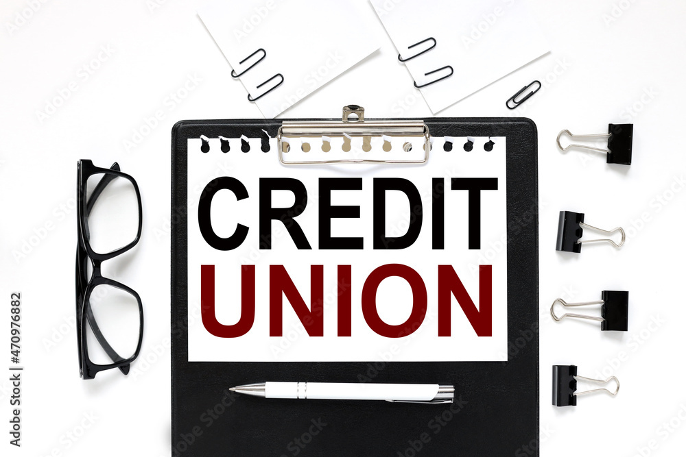 Credit Union. black clipboard, with a white sheet of paper on a white background. black glasses. business concept Credit Union. black clipboard, with a white sheet of paper on a white background. black glasses. business concept