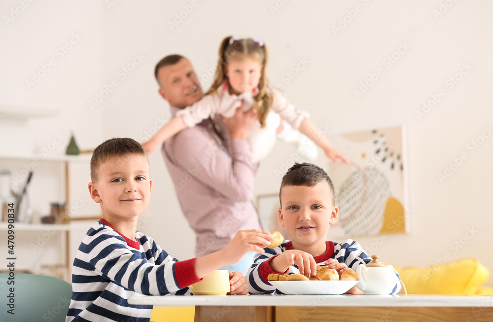 Happy father with his little children spending time together at home