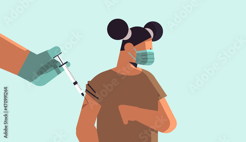 doctor hand vaccinating girl patient in medical mask fight against coronavirus vaccine development concept