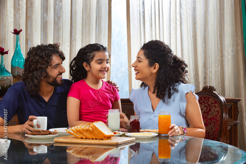 Family sharing an intimate moment at the breakfast table in the moring at home photo