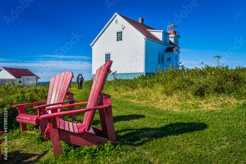Red Canada park Adirondacks chairs and the lighthouse keeper house on Ile aux Perroquets, one of Mingan Archipelago island in Cote Nord region of Quebec (Canada) photo