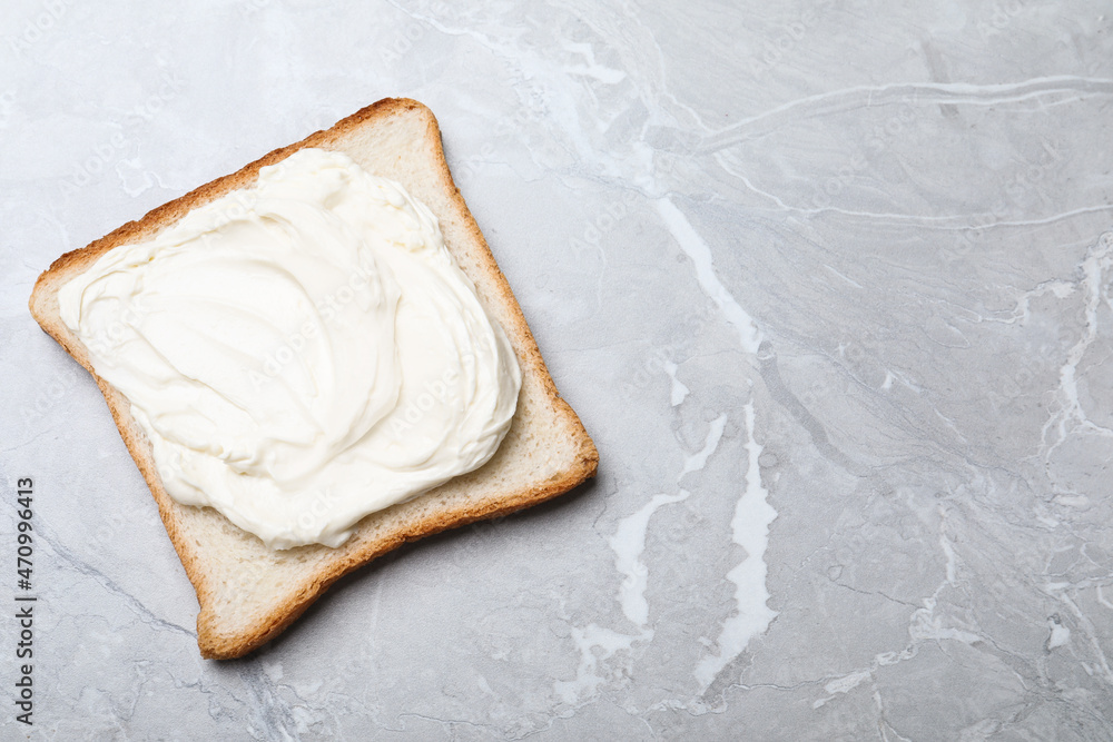 Slice of bread with tasty cream cheese on light grey marble table, top view. Space for text Slice of bread with tasty cream cheese on light grey marble table, top view. Space for text