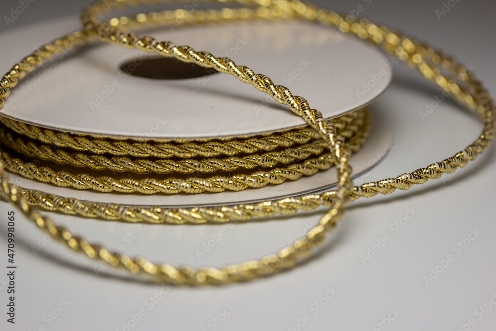 Macro abstract texture background of sparkling gold color Christmas holiday twisted fabric rope cord with copy space Macro abstract texture background of sparkling gold color Christmas holiday twisted fabric rope cord with copy space