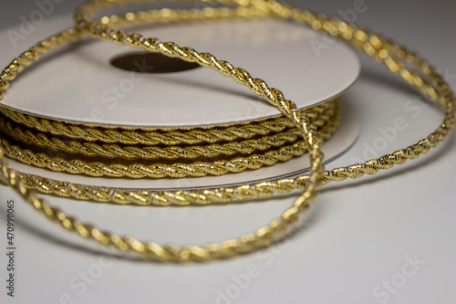 Macro abstract texture background of sparkling gold color Christmas holiday twisted fabric rope cord with copy space