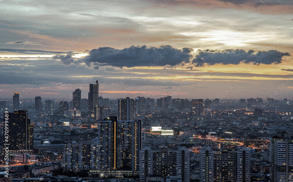 Fototapeta premium Bangkok, Thailand - Jul 31, 2021 : Aerial view of Beautiful scenery view of Skyscraper Evening time with bright glowing lights at dusk creates relaxing feeling for the rest. No focus, specifically.