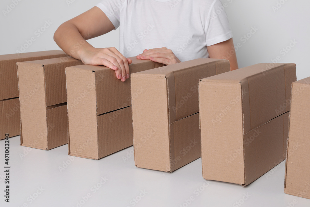 Woman folding cardboard boxes at white table, closeup. Production line Woman folding cardboard boxes at white table, closeup. Production line