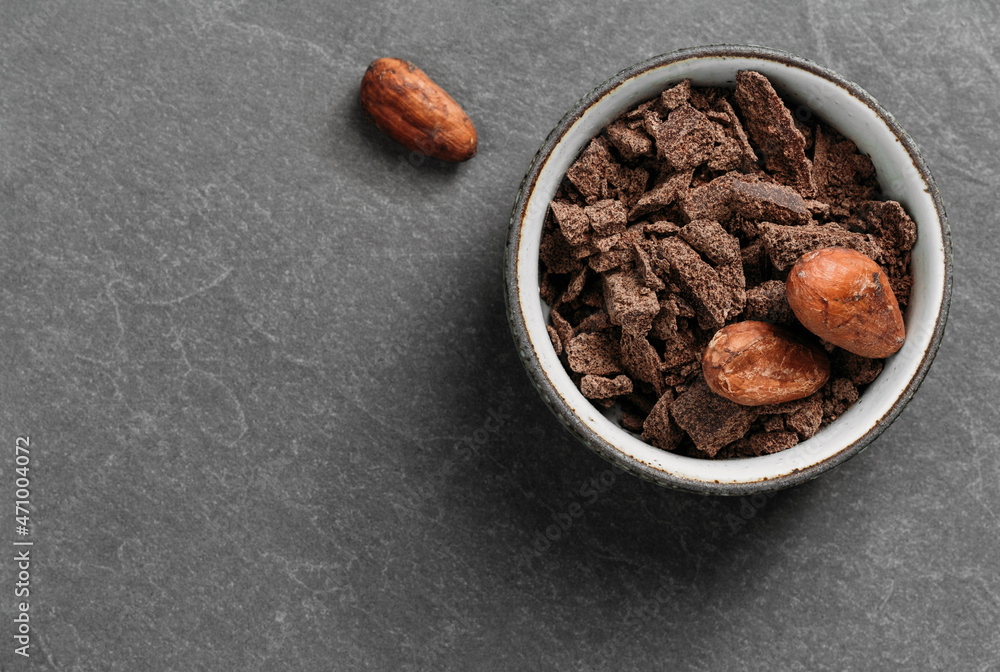 Chocolate crumbs in bowl ready for cooking top view. Organic fermented or raw cacao beans for hot drinks. Flat lay with copy space for recipe. Ingredients for sweet food Chocolate crumbs in bowl ready for cooking top view. Organic fermented or raw cacao beans for hot drinks. Flat lay with copy space for recipe. Ingredients for sweet food