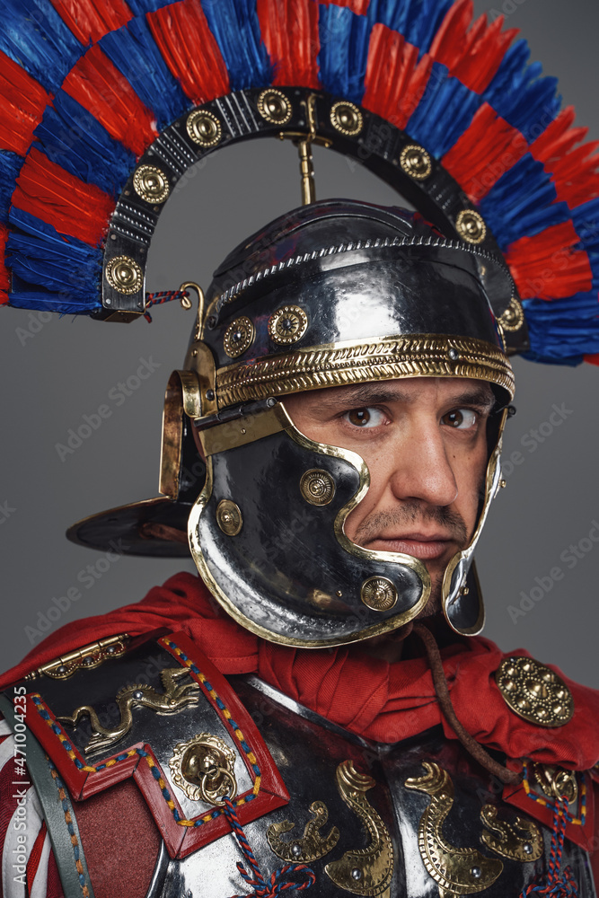 Ancient imperial legionary with helmet against gray background