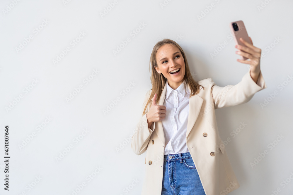 Portrait of a smiling businesswoman taking selfie with mobile phone isolated over white background Portrait of a smiling businesswoman taking selfie with mobile phone isolated over white background