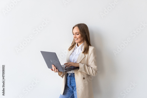 Successful business woman is standing with laptop on white background.