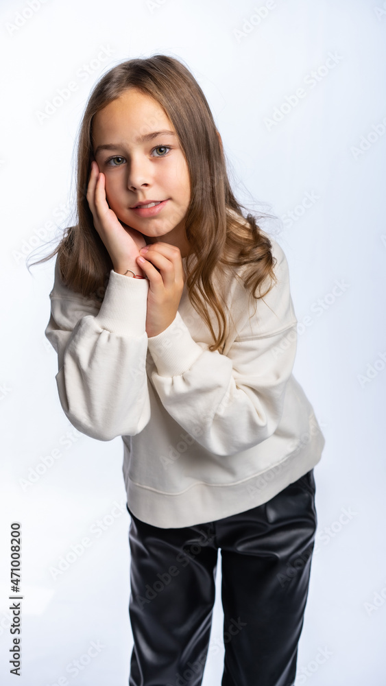 portrait of a girl in the studio. beautiful little girl in a white sweatshirt and trousers is smiling. isolated white background portrait of a girl in the studio. beautiful little girl in a white sweatshirt and trousers is smiling. isolated white background