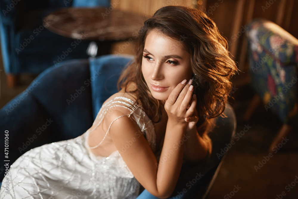 Portrait of an adorable young woman with perfect trendy makeup and full seductive lips in a luxurious dress