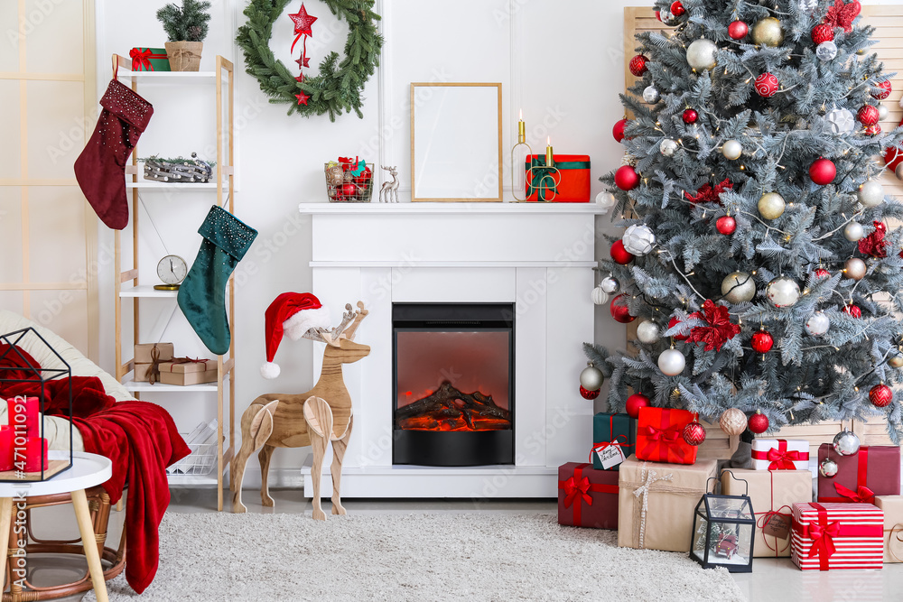 Obraz premium Beautiful Christmas tree, armchair and fireplace in decorated living room