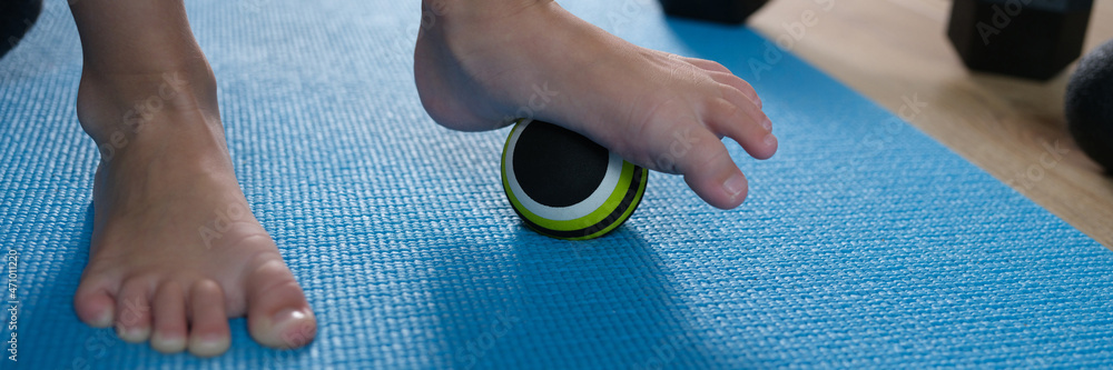 Fototapeta premium Child foot standing on small sports ball closeup
