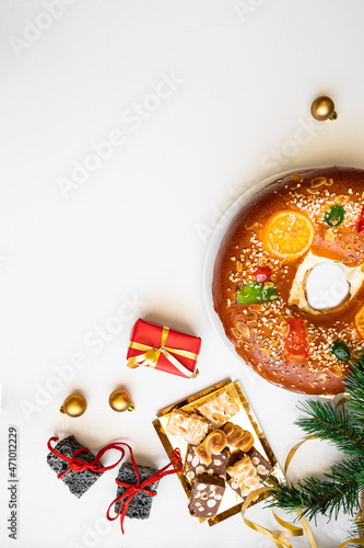  Spanish Christmas concept. Roscon de reyes, Spanish cake , sweet coal , turrones and red  gift boxes  on white background