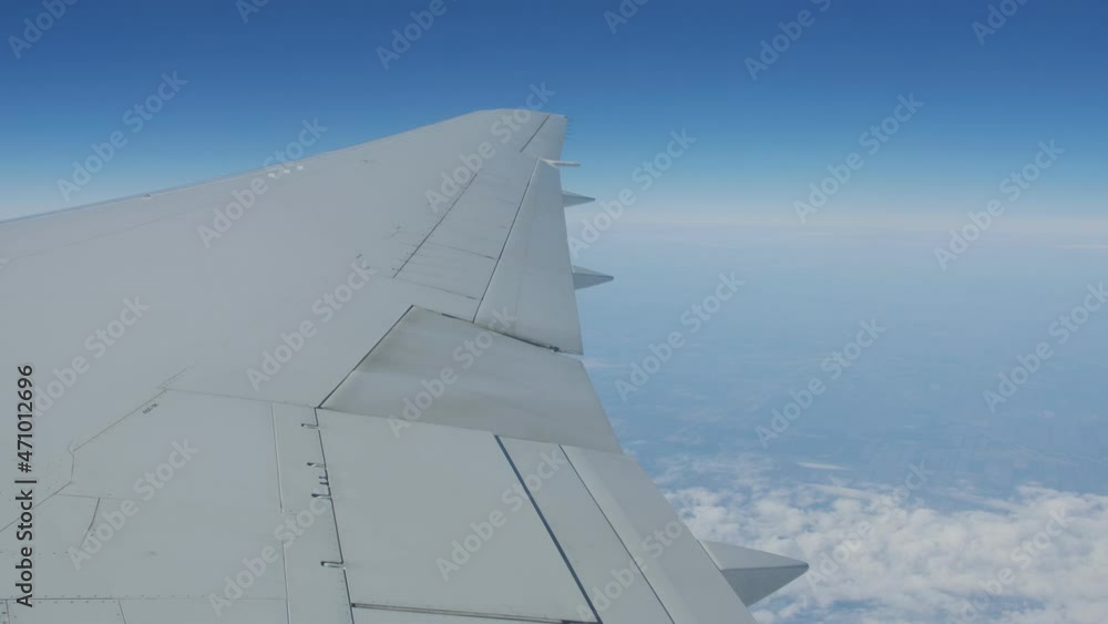 The view from the window of the plane on the wing hovering against the blue sky. Flying by plane. The view from the window of the plane on the wing hovering against the blue sky. Flying by plane.