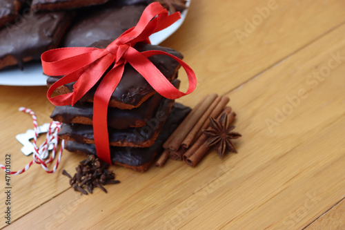 Stack of traditional italian Mostaccioli cookies tied with red ribbon on wooden table photo