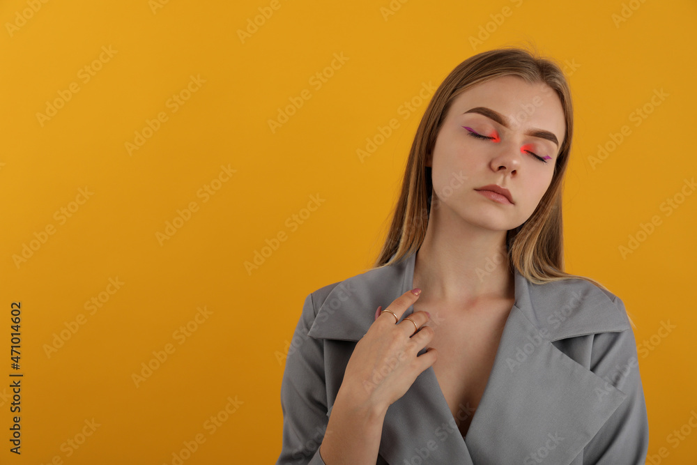 Beautiful model girl in autumn cloak on yellow background Beautiful model girl in autumn cloak on yellow background