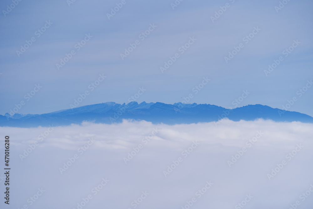 Sea of fog with Swiss alps in the background and cloudy blue sky on a autumn day. Photo taken November 19th, 2021, Zurich, Switzerland. Sea of fog with Swiss alps in the background and cloudy blue sky on a autumn day. Photo taken November 19th, 2021, Zurich, Switzerland.