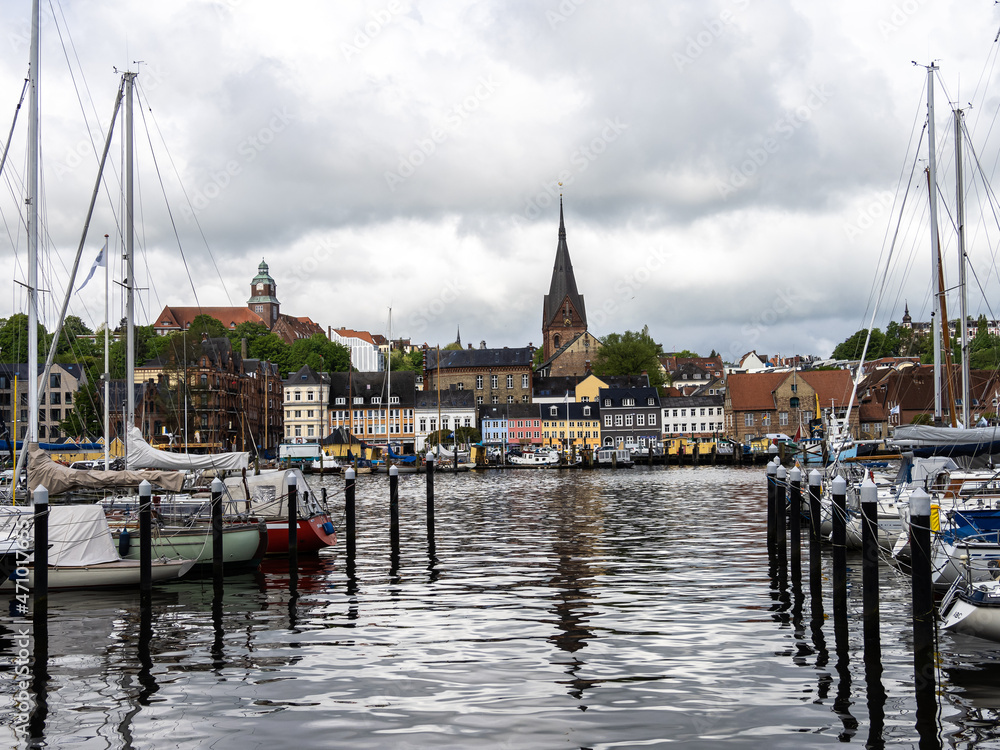 Fototapeta premium Sail boats in the port of Flensburg, St. Jorgen's Church in the background. Schleswig-Holstein in Germany
