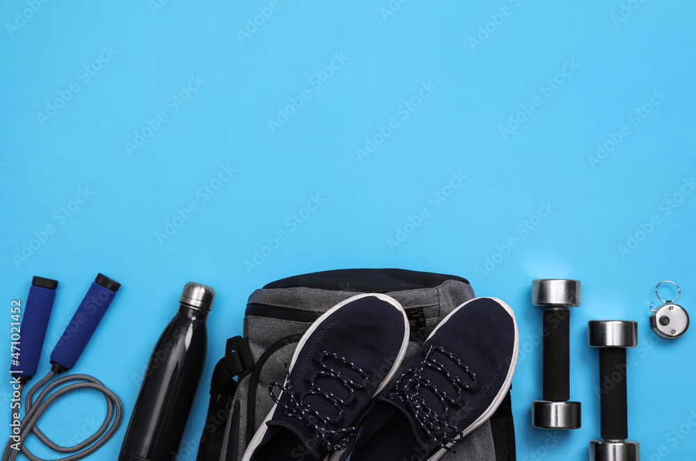 Gym bag and sports equipment on light blue background, flat lay. Space for text Gym bag and sports equipment on light blue background, flat lay. Space for text