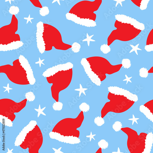 Christmas seamless pattern with Santa Claus red hat isolated on blue background. Xmas winter design for textile  wrapping paper  greeting cards.