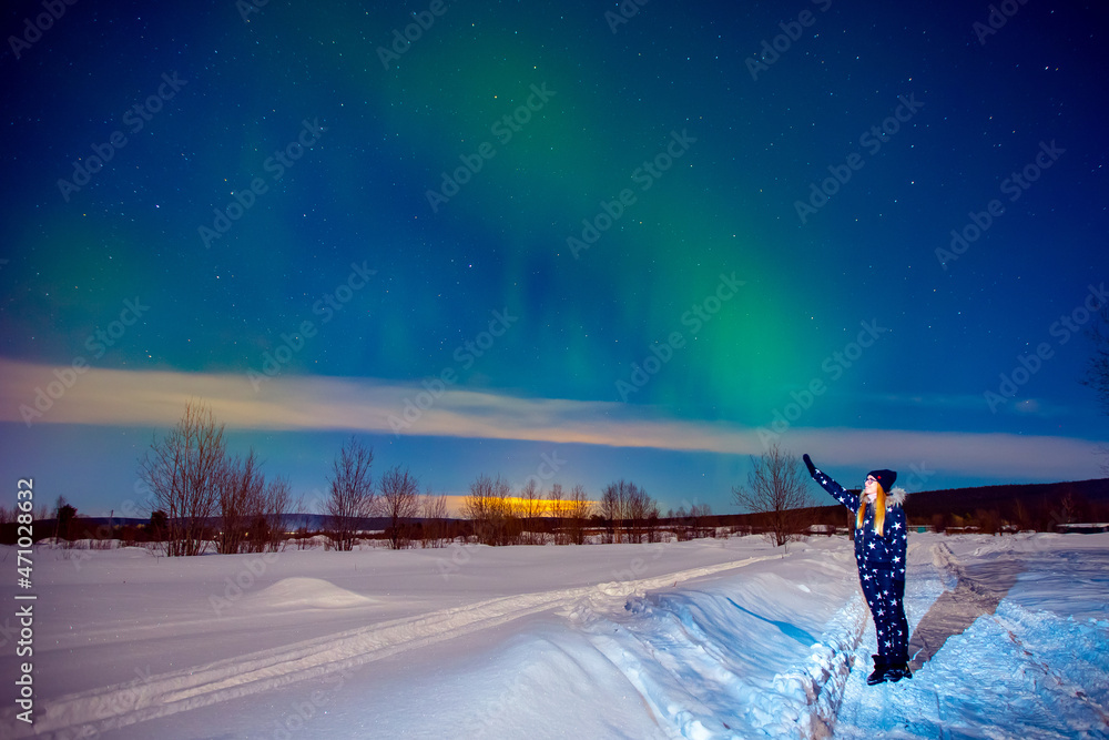 Woman tourist looks aurora northern lights night at forest, soft focus